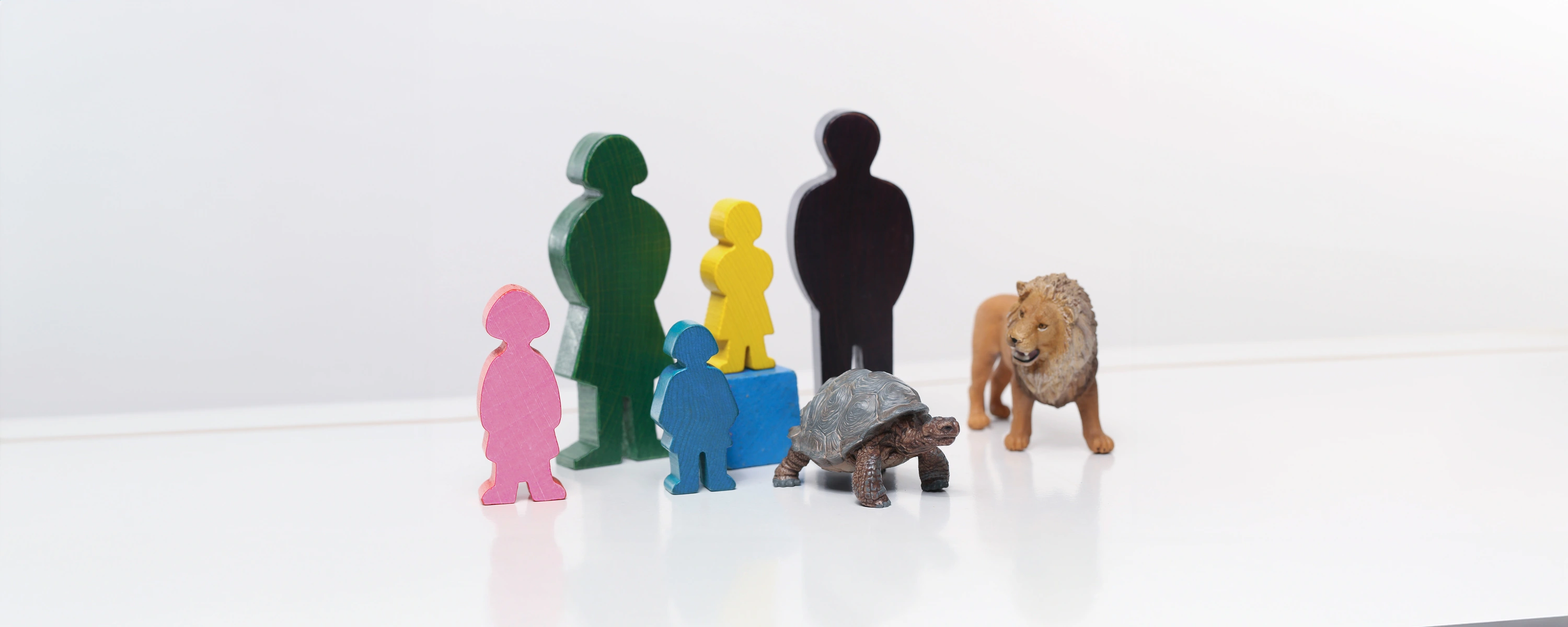 eine Mehrpersonen-Aufstellung mit Holzfiguren, einem Löwen, einem Skorpion und herumliegenden Holzsteinen